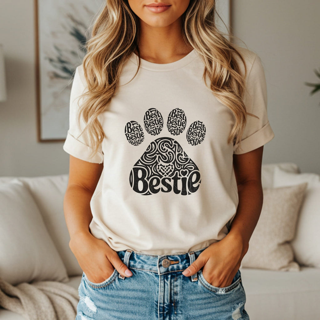 Cream t-shirt with black paw print graphic saying "Bestie" repeatedly.