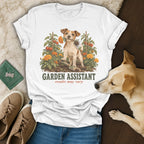 A white t-shirt featuring a vintage illustration of a Jack Russell terrier holding a plant with the text "Garden Assistant" below.