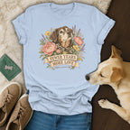 A light blue t-shirt with a graphic of an elderly dog, flowers, and the text "Fewer Years More Love Adopt A Senior Dog."