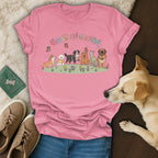 T-shirt with cartoon dogs, butterflies, flowers, and "Paws in Bloom" text.