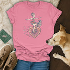 Pink t-shirt with a woman riding a heart-shaped bicycle with a dog in the basket.