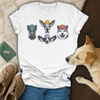 T-shirt with four dog portraits wearing beanies, laid flat with accessories.