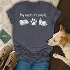 Dark gray t-shirt with "My needs are simple." and icons of a book, paw print, candle, and tea.