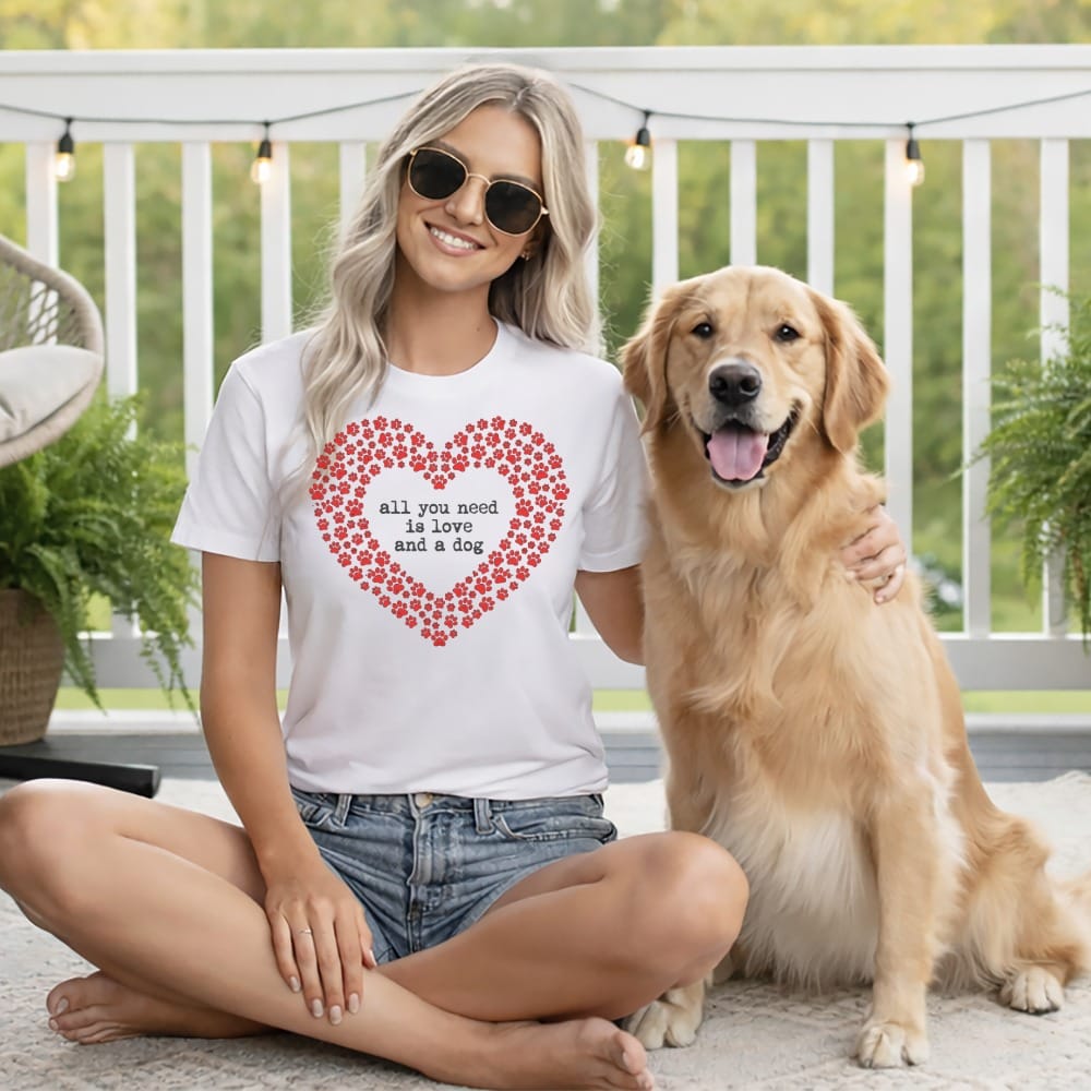 Woman in white t-shirt with red heart paw print design and dog.