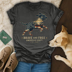 Dog wearing patriotic shirt with "Brave and Free America's 250th" text.
