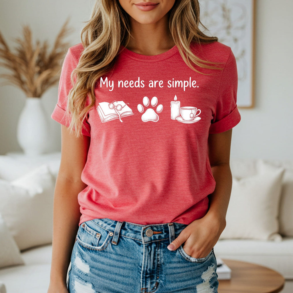 T-shirt with text "My needs are simple" and icons of book, paw, candle, teacup.