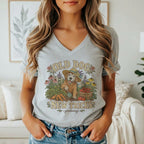 A woman wearing a gray V-neck t-shirt featuring a vintage gardening golden retriever graphic and text.