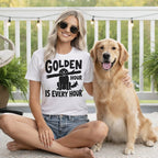 Woman with golden retriever wearing t-shirt with "golden hour is every hour" text.