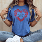 Blue t-shirt with a heart made of red paw prints and text.