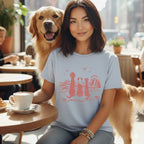 Woman with golden retriever at cafe, wearing t-shirt with dogs and wave graphic.