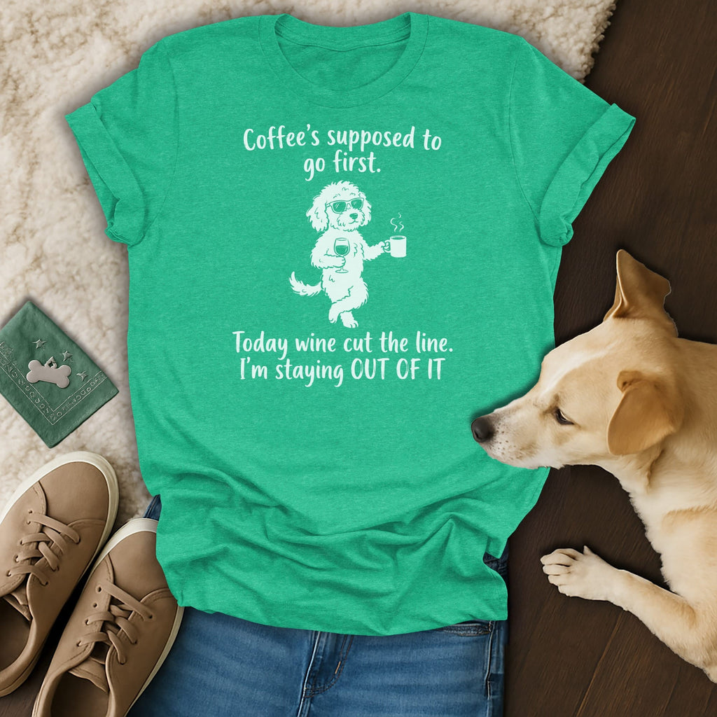 Green t-shirt with a cartoon dog holding coffee and wine, text reads "Coffee's supposed to go first. Today wine cut the line. I'm staying OUT OF IT."