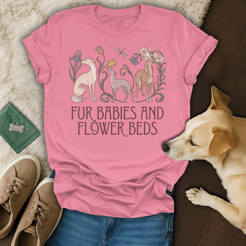 A pink t-shirt with greyhound dogs and flowers printed on the front rests on a surface next to a real dog, sneakers, and a green passport.