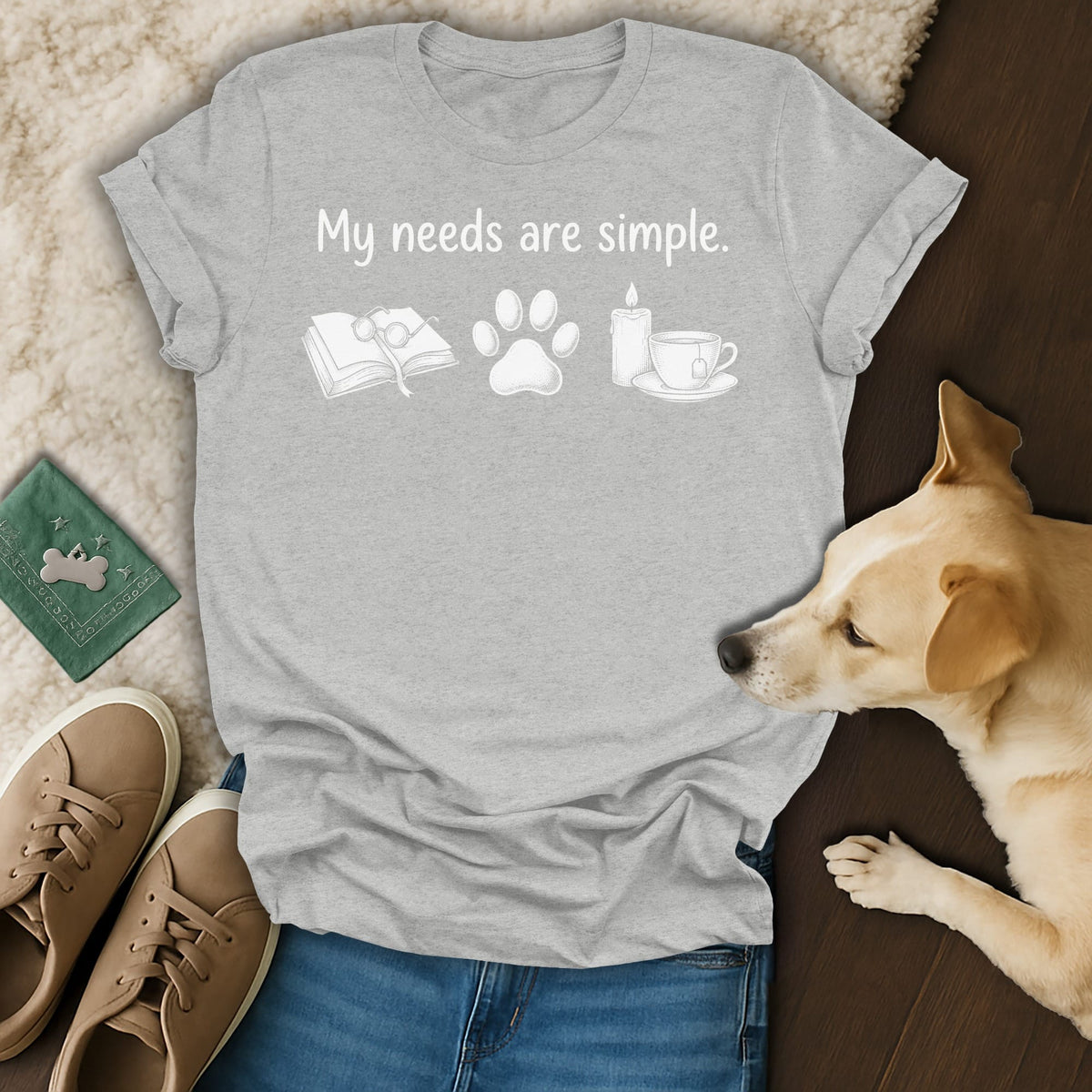 Grey t-shirt with white text and icons: book, paw print, candle, and teacup.