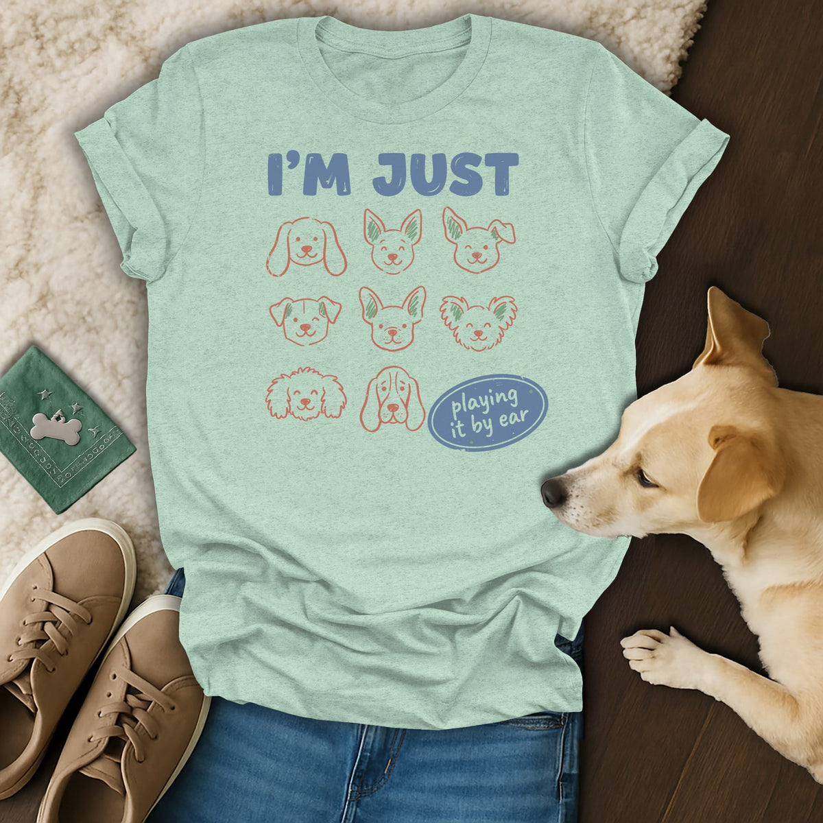 Light green t-shirt with dog faces and "I'M JUST playing it by ear" text.