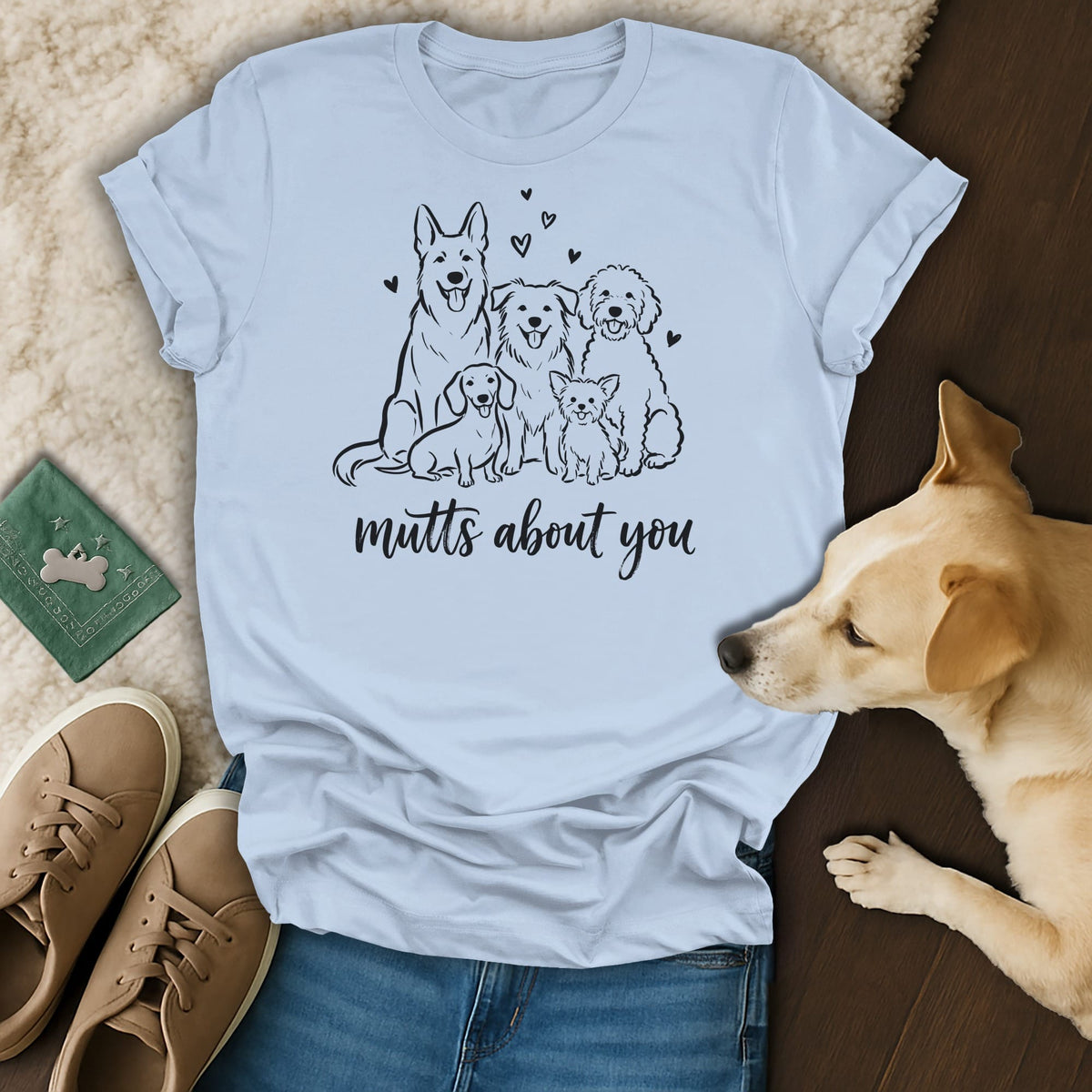 Light blue t-shirt with black line drawing of five dogs and text "mutts about you".