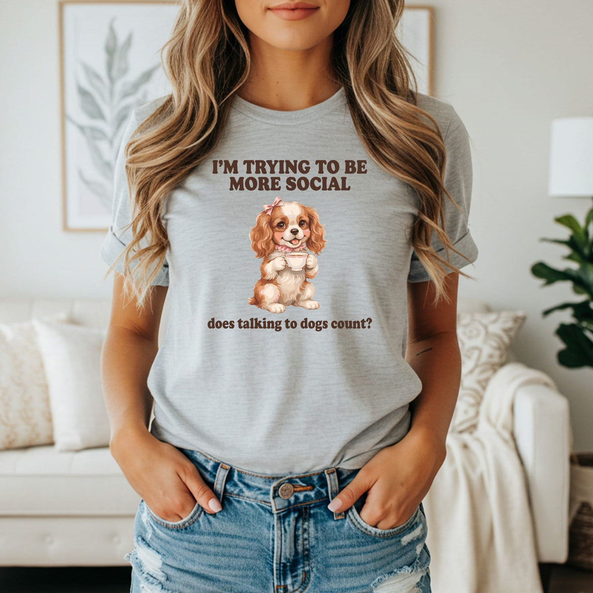 "I'm trying to be more social," text above a Cavalier King Charles Spaniel holding a teacup.