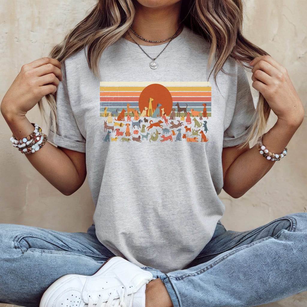 Grey t-shirt with retro sunset and dogs graphic.