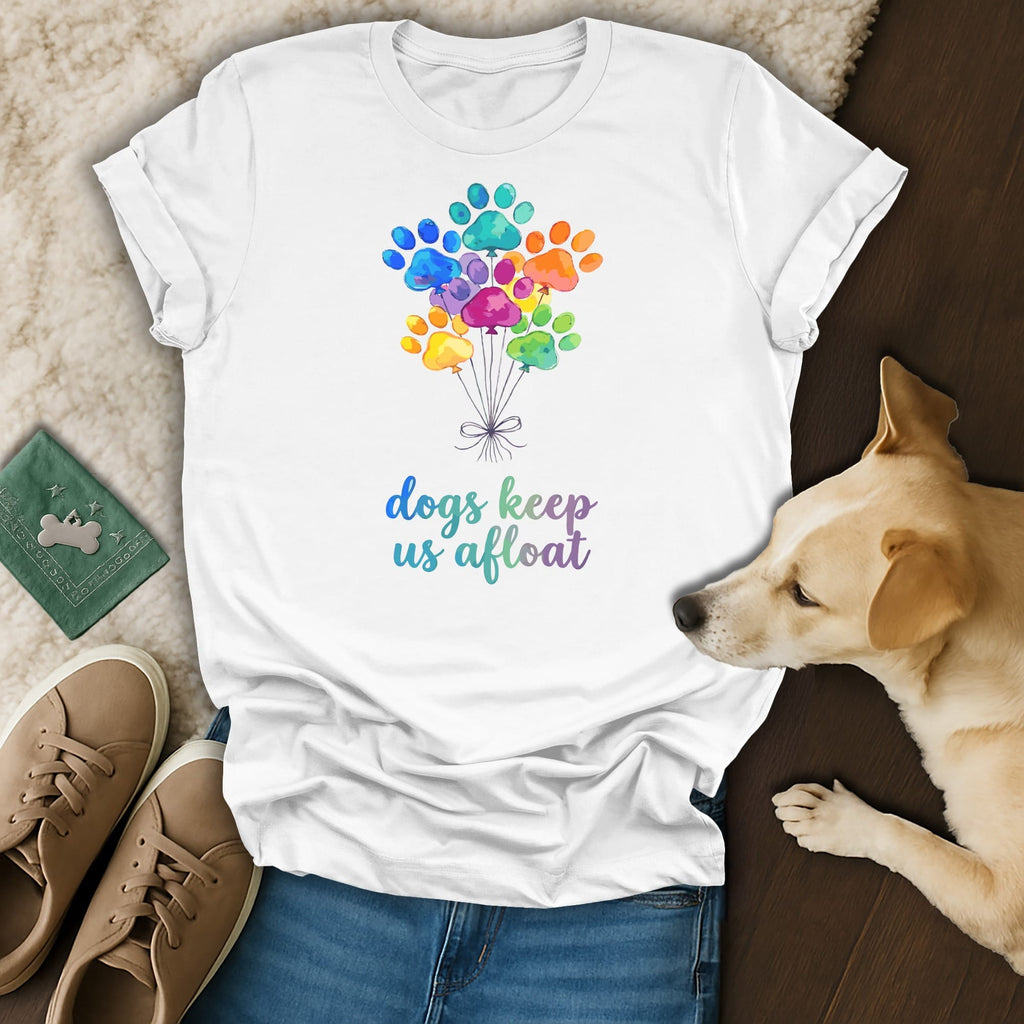 White t-shirt with colorful paw print balloons and text "Dogs keep us afloat".
