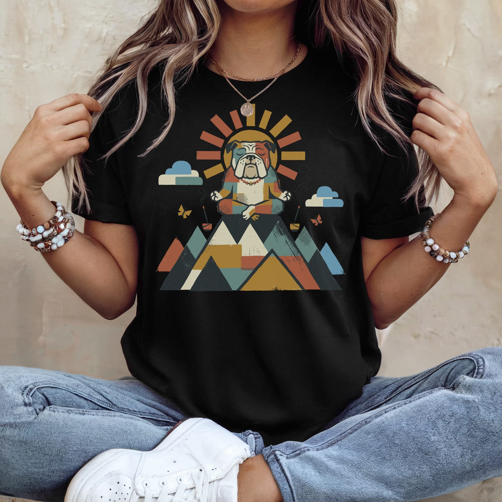 Bulldog meditating in colorful geometric mountains with sun and clouds graphic on black t-shirt.