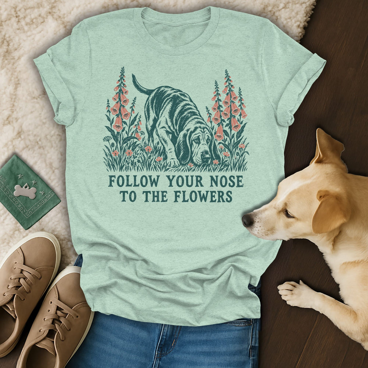 Light green t-shirt with a vintage-style dog graphic and the text FOLLOW YOUR NOSE TO THE FLOWERS.