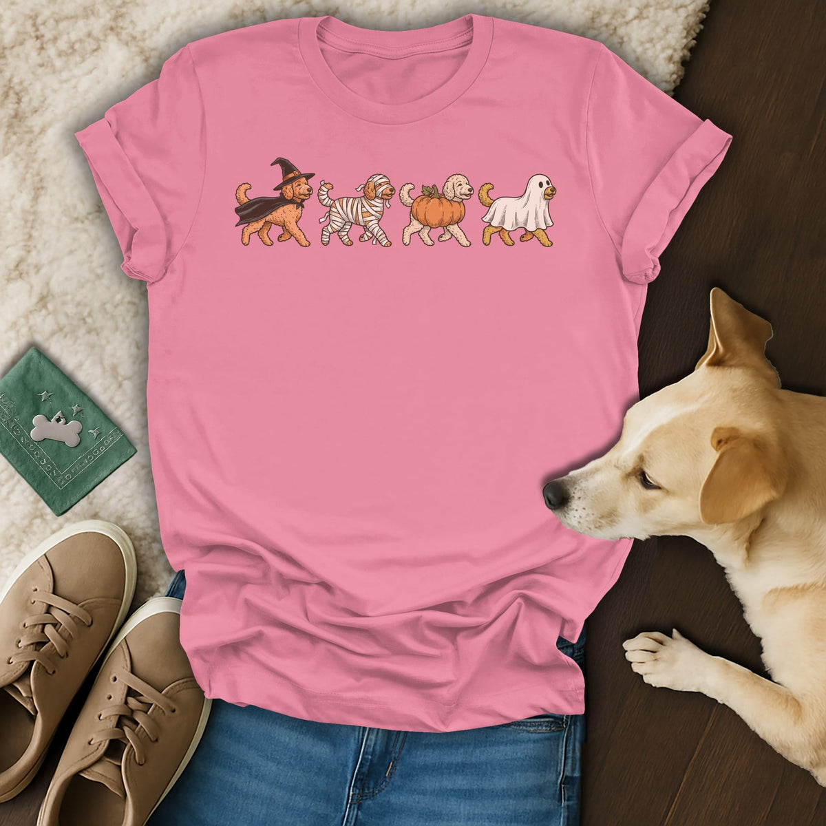 Pink t-shirt with four dogs in Halloween costumes walking in a line.