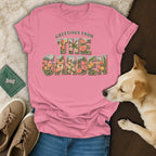 A pink t-shirt with the graphic text "Greetings from the Garden" featuring flowers and a corgi.