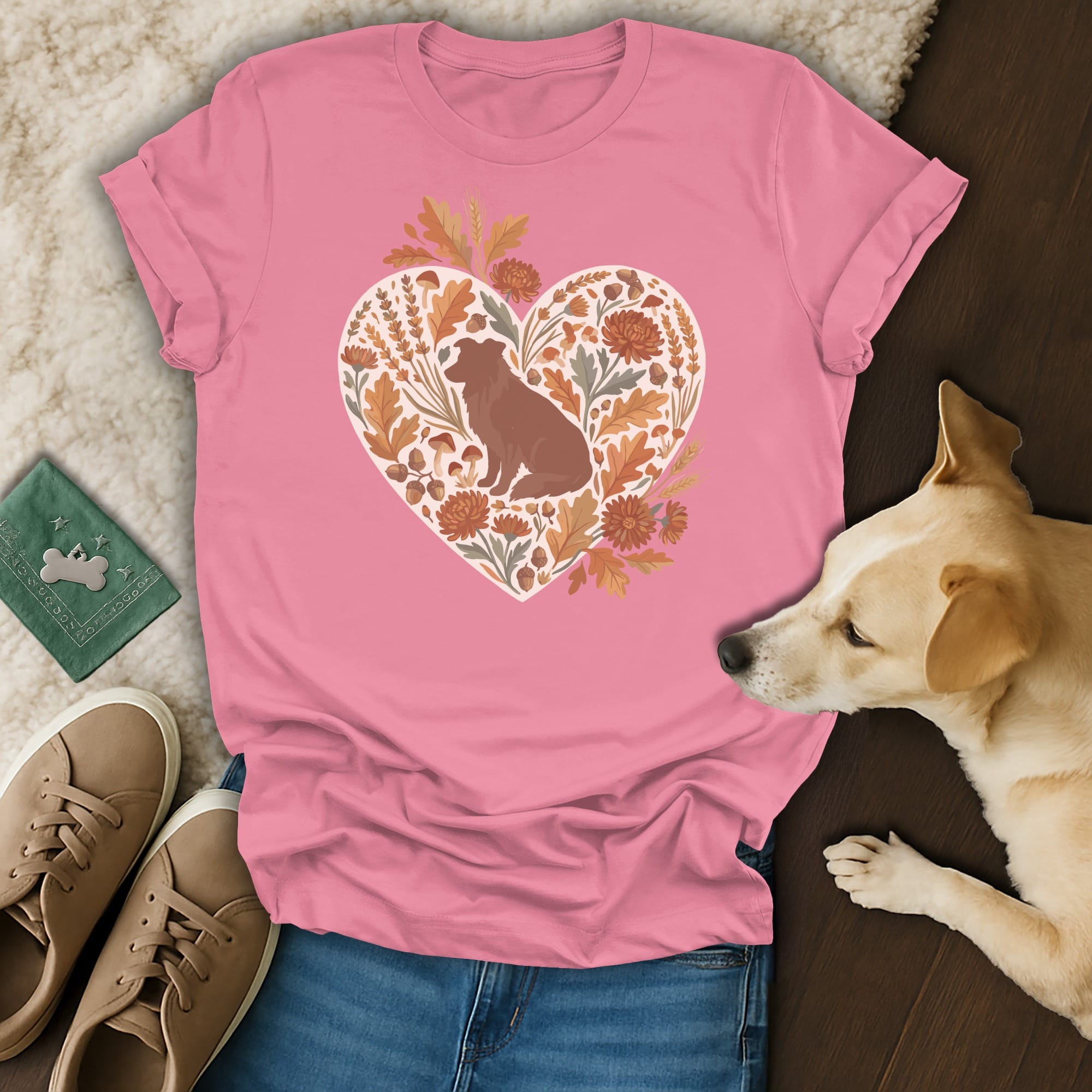 Pink t-shirt with a heart graphic of a dog among autumn leaves and mushrooms.