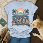 Light blue t-shirt with four dogs on a cruise ship deck with palm trees.