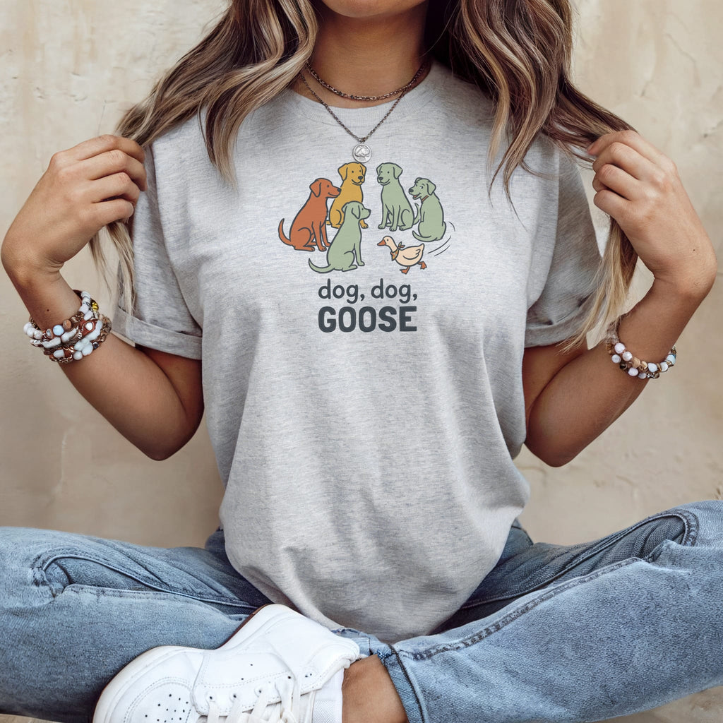 Light gray t-shirt with cartoon dogs and a goose graphic, reading "dog, dog, GOOSE".