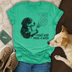 T-shirt with a dog blowing dandelion seeds, text "Paws and Make a Wish".