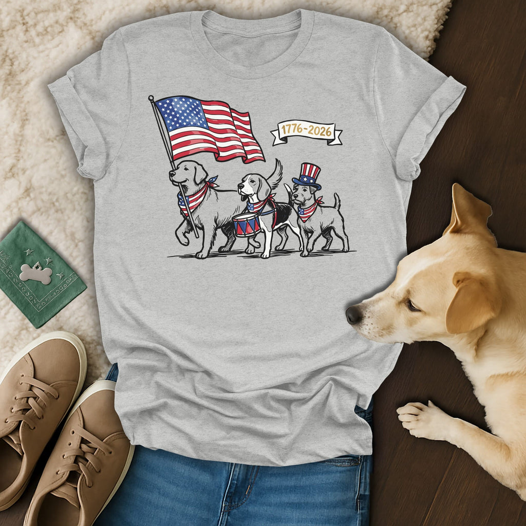 Dogs in patriotic attire march with an American flag and drum, "1776-2026" text.