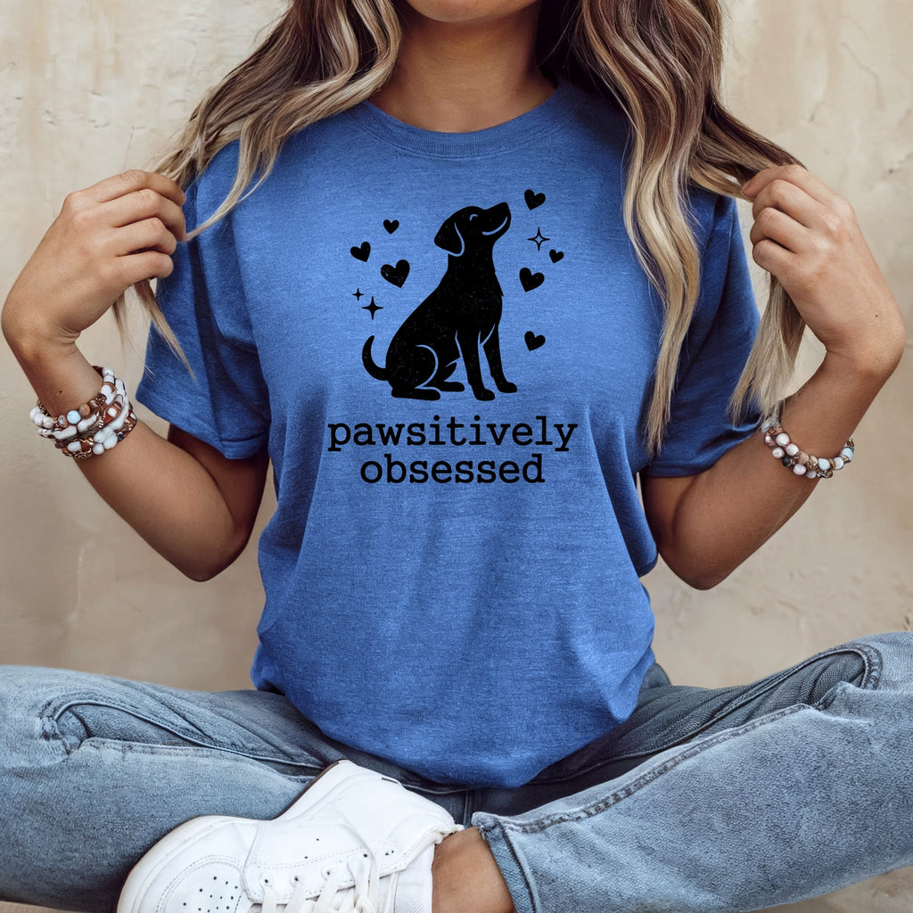 Blue t-shirt with black dog silhouette, hearts, and text "Pawsitively obsessed".