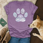 Purple t-shirt with winter animal and nature scenes inside a paw print outline.