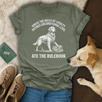 Golden retriever standing on books with "Wrote the rules of loyalty, defined unconditional love. Ate the rulebook." text.