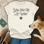 Cream t-shirt with "You HAD Me At Woof" text and paw print, with dog and accessories.