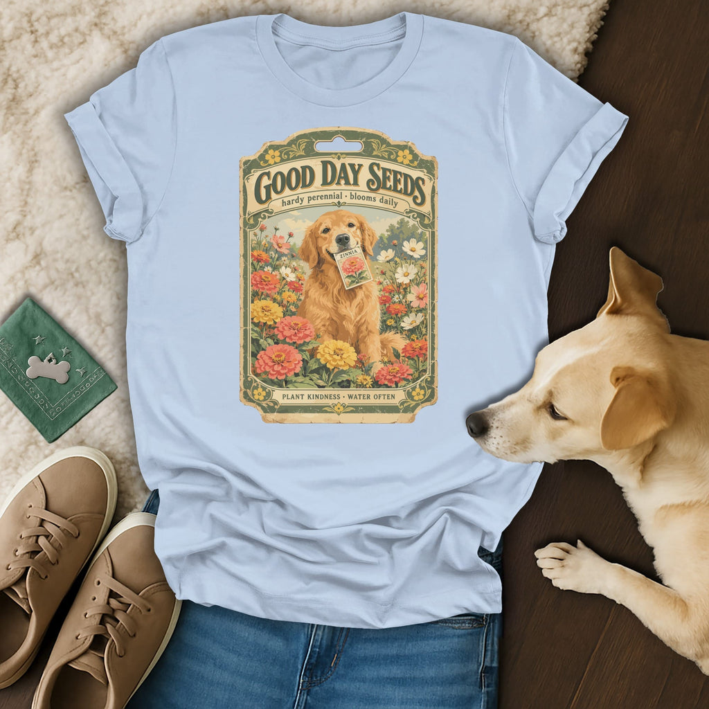 Light blue t-shirt featuring a vintage seed packet graphic with a golden retriever holding a zinnia packet amidst flowers.