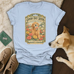 Light blue t-shirt featuring a vintage seed packet graphic with a golden retriever holding a zinnia packet amidst flowers.