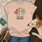 Peach t-shirt with cartoon dogs and a duck, and text "dog, dog, GOOSE".