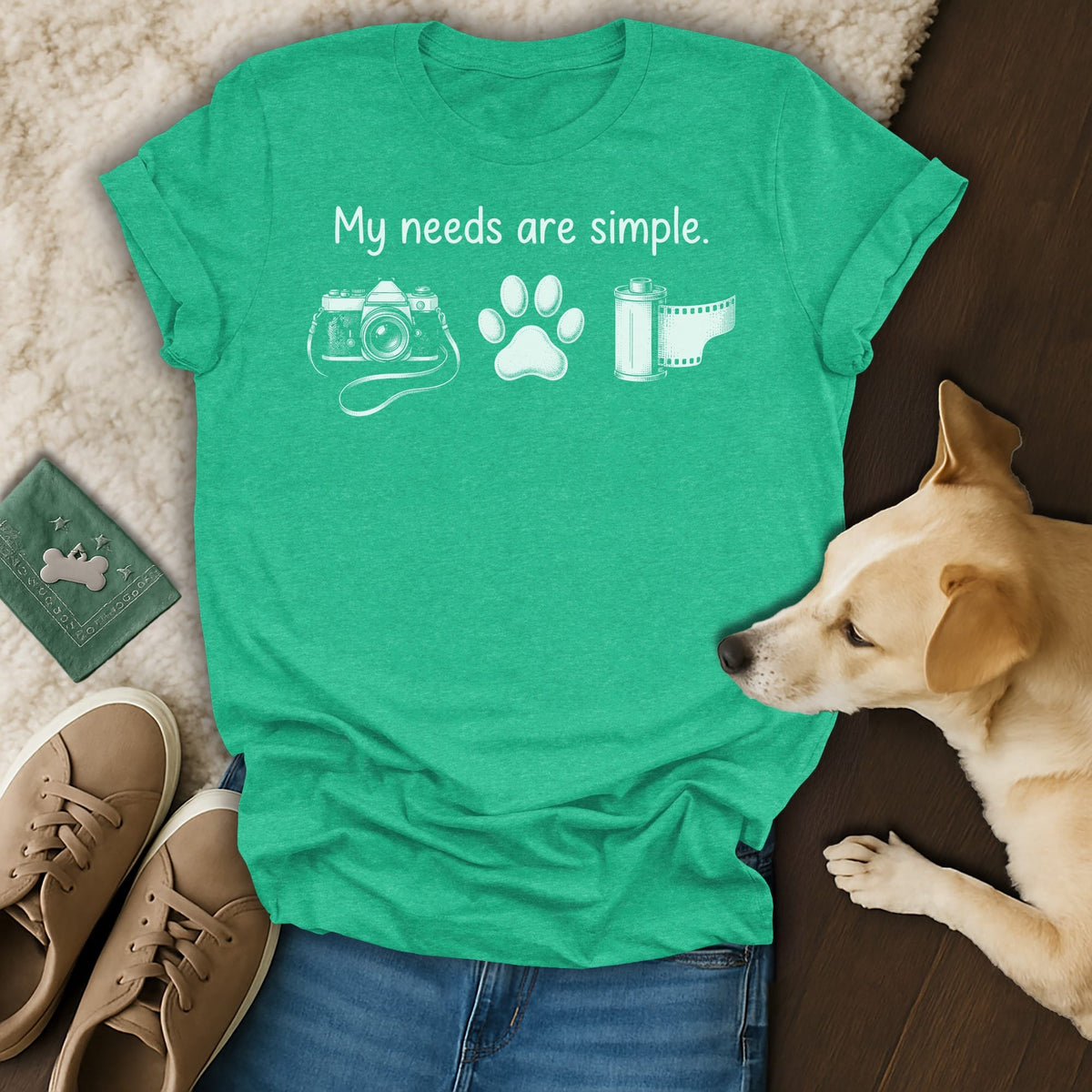 Green t-shirt with "My needs are simple," camera, paw, and film.