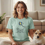 Woman in light green t-shirt with dog and kite illustration.