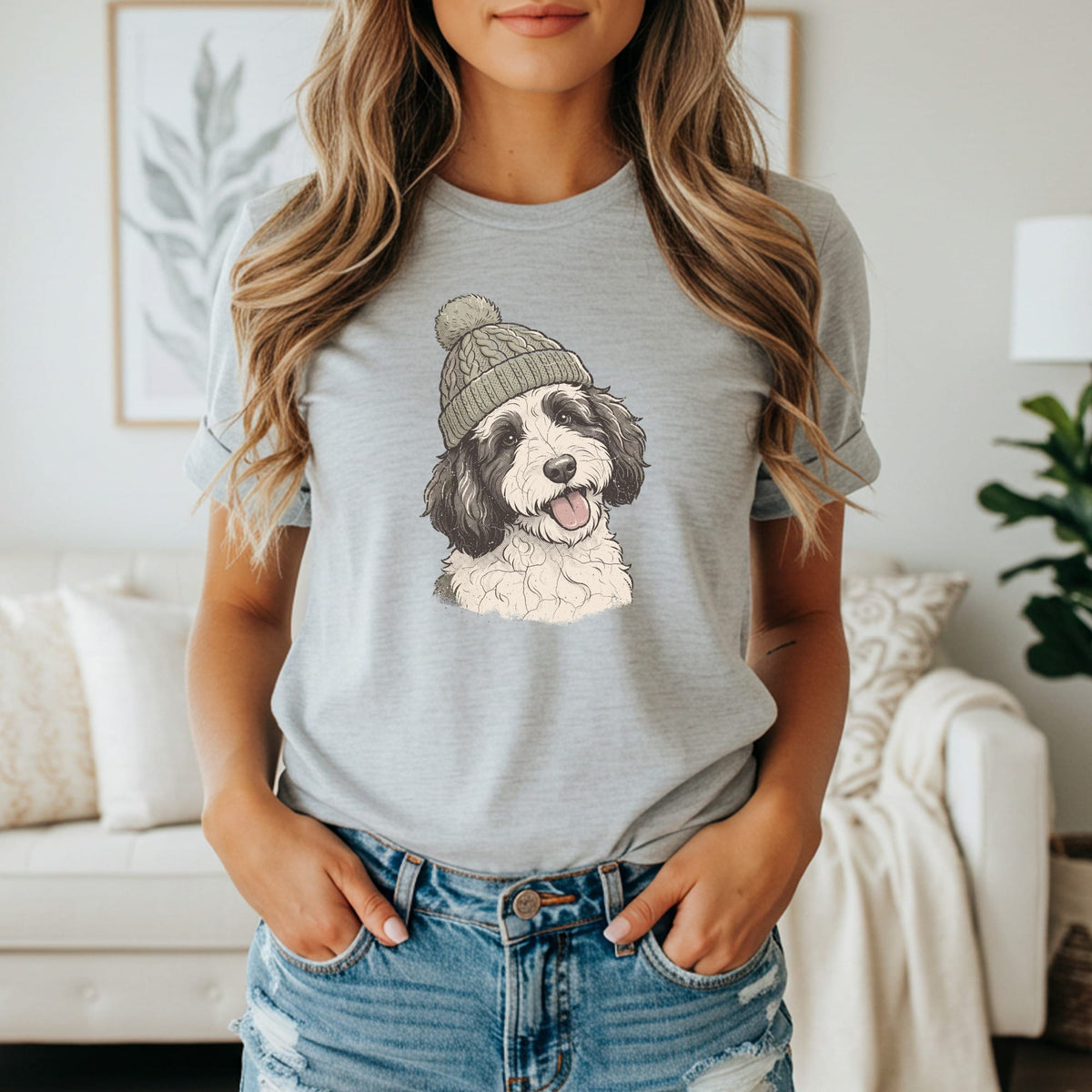 Light grey t-shirt with graphic print of a black and white dog wearing a knit hat.