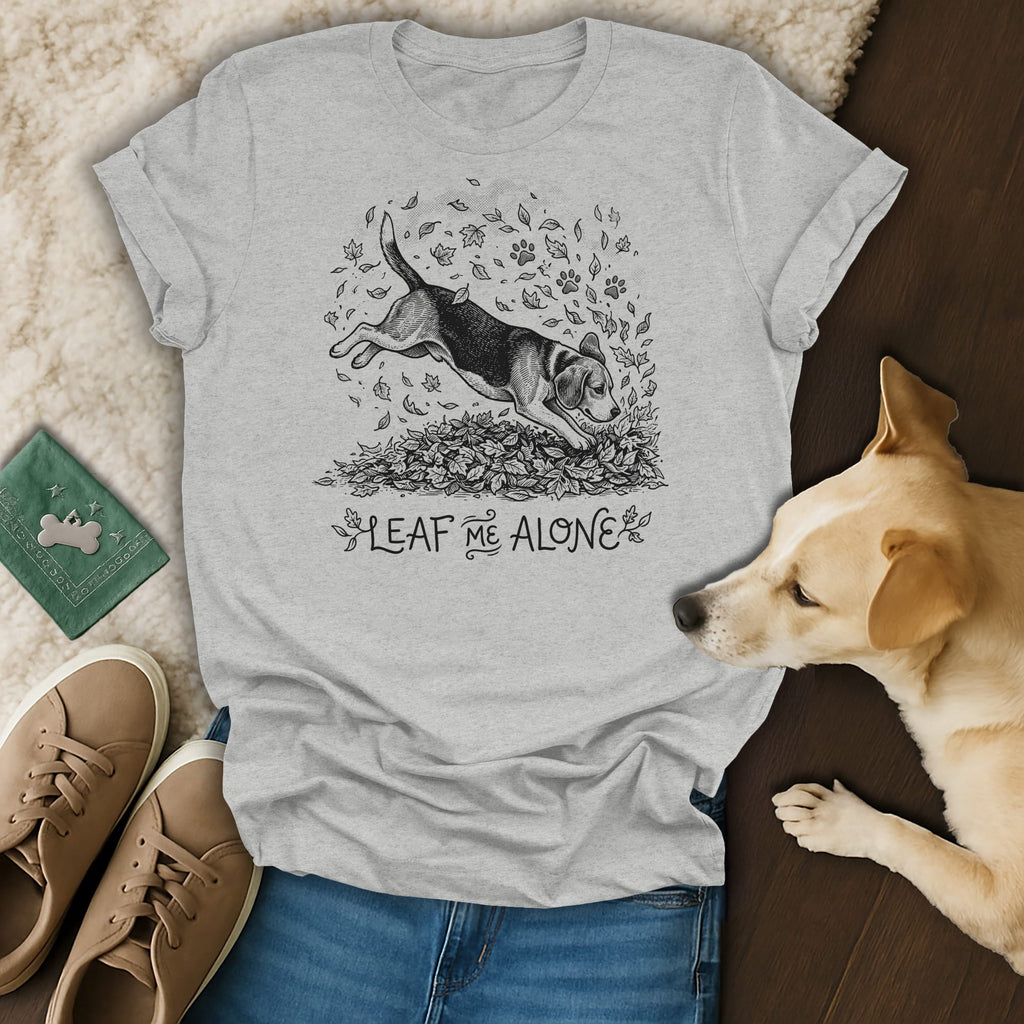 Light grey t-shirt with a dog jumping into leaves and text "LEAF ME ALONE".