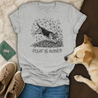 Light grey t-shirt with a dog jumping into leaves and text "LEAF ME ALONE".