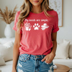 Red t-shirt with white graphic: "My needs are simple.", potted flowers, paw print, and gardening hat.