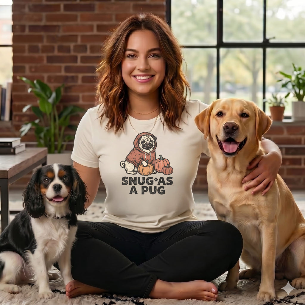 Woman in t-shirt with "Snug as a Pug" graphic and two dogs.