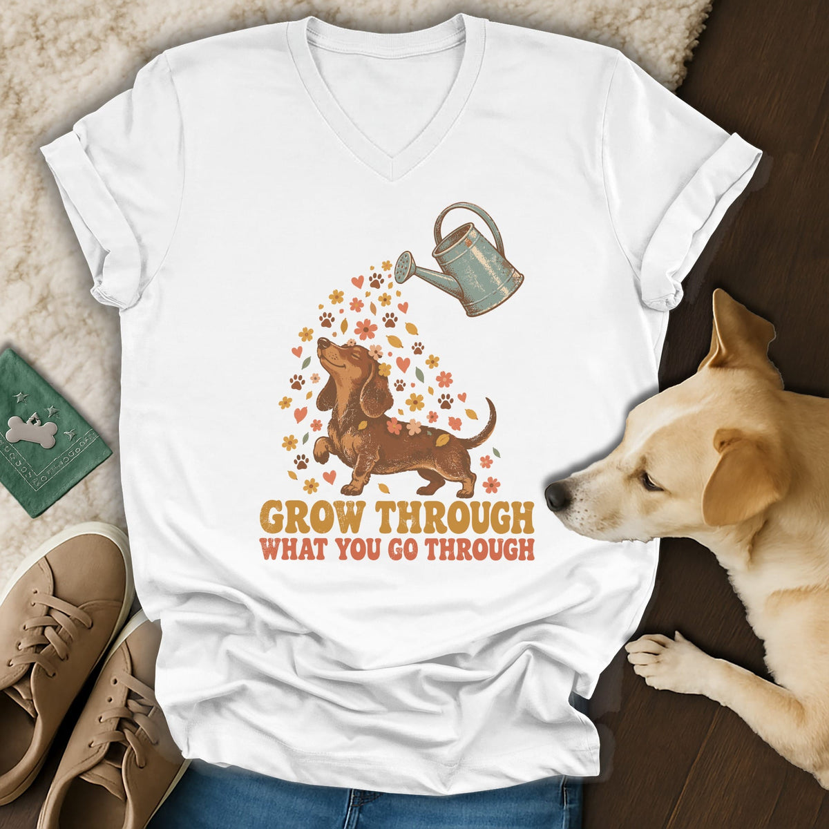 White V-neck t-shirt featuring a dachshund graphic, flowers, a watering can, and the text GROW THROUGH WHAT YOU GO THROUGH.