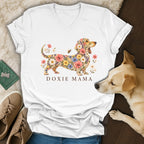 A white v-neck t-shirt featuring a floral dachshund graphic and the text DOXIE MAMA.