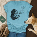 Puppy in drawing holds dandelion, releasing paw-print seeds into the air.