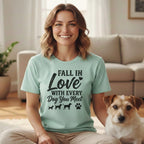 Woman in light green t-shirt with "Fall in Love with Every Dog You Meet" text and dog silhouettes.