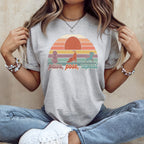 Gray t-shirt with "Paws, Pose, Repeat" yoga dog graphic and sunset.